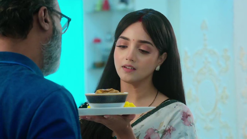 Anjali serving food to Raghav at the dining table