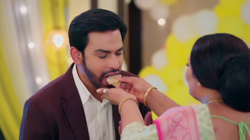 Kusum feeding Mangal a piece of suji halwa, both smiling happily