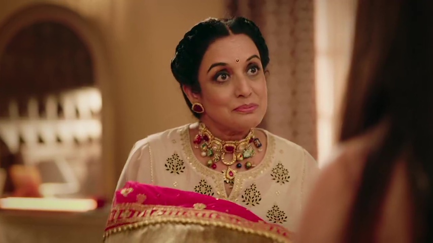 Neetu handing the chunri to Mallika, with a warm smile