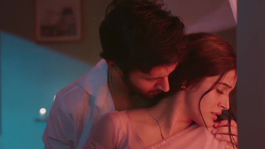 Om and Isha hugging in a candlelit room, showing their bond