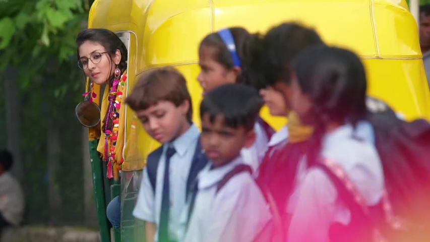 Preeth helping school children cross the muddy path with a bright smile