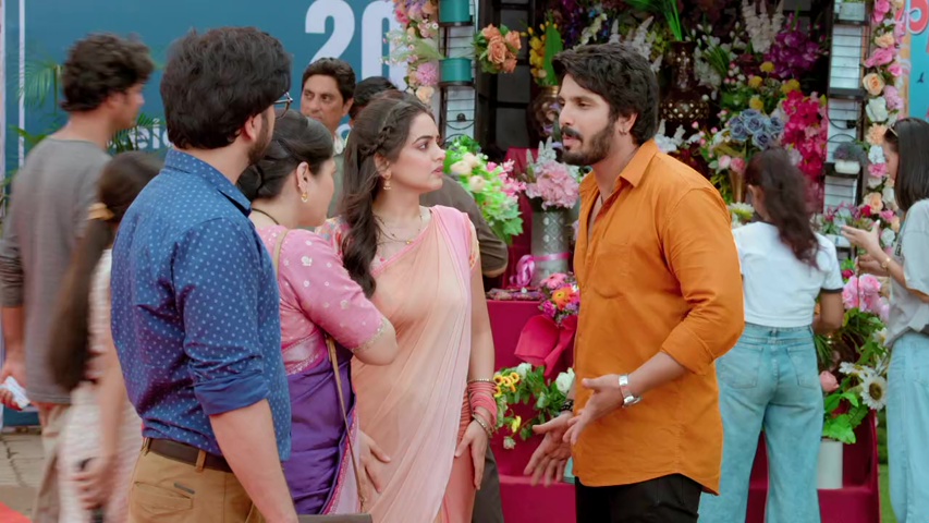 Sachin and Sayali selling flowers outside the flea market with a crowd around them