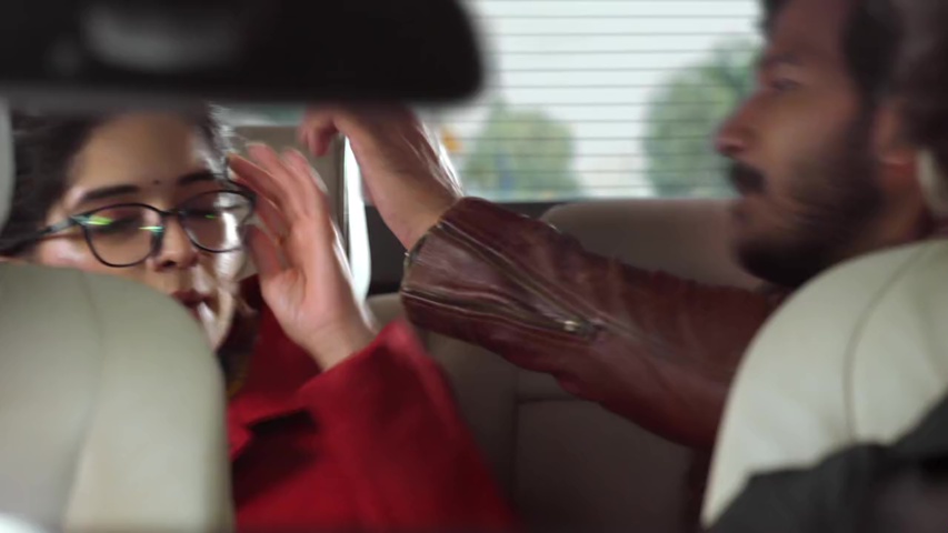 Savi and Maruti in the car, with Maruti holding her broken spectacles