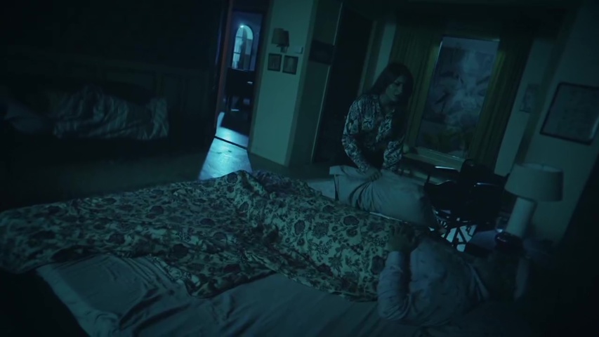 Sowmya holding a pillow near Sudesh as Mangal enters the room