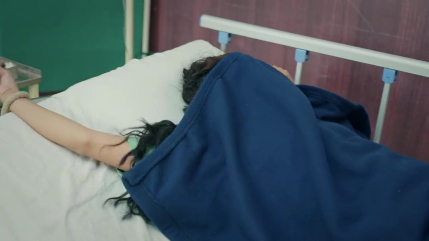 hospital scene with a covered figure and a watchful nurse